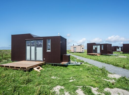 Eine der Besonderheiten der Green Tiny Houses ist, dass nicht nur einzelne Minihäuser gebaut, sondern ganze Minidörfer aufgestellt werden. Dafür arbeitet das Unternehmen, wie es auch bei Reihenhäusern der Fall ist, mit zuvor festgelegten Designs, die das Ortsbild bestimmen und für ein einheitliches Erscheinungsbild sorgen.  | © Green Tiny Houses