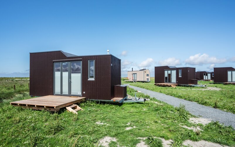 Eine der Besonderheiten der Green Tiny Houses ist, dass nicht nur einzelne Minihäuser gebaut, sondern ganze Minidörfer aufgestellt werden. Dafür arbeitet das Unternehmen, wie es auch bei Reihenhäusern der Fall ist, mit zuvor festgelegten Designs, die das Ortsbild bestimmen und für ein einheitliches Erscheinungsbild sorgen.  | © Green Tiny Houses