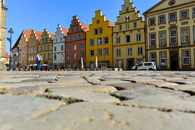 Bunte Reihenhäuser in Osnabrück mit Kopfsteinpflaster im Vordergrund | © Ilhan Balta/Adobe Stock