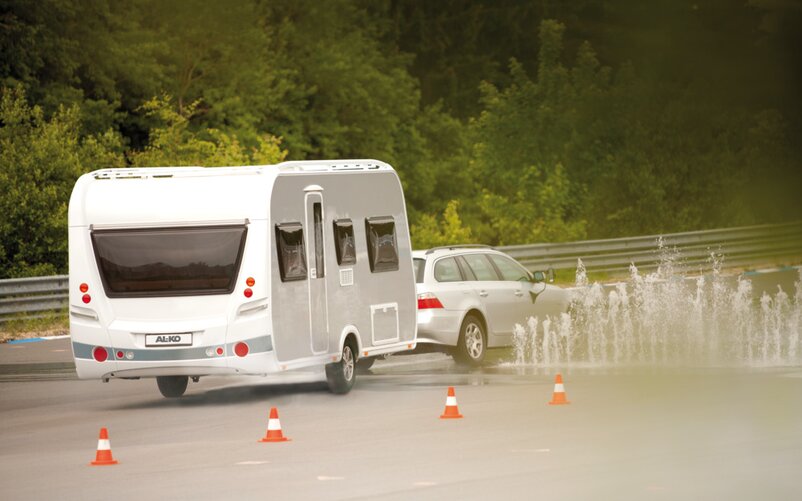 A car with a caravan is taking part in a driver safety training. | © AL-KO