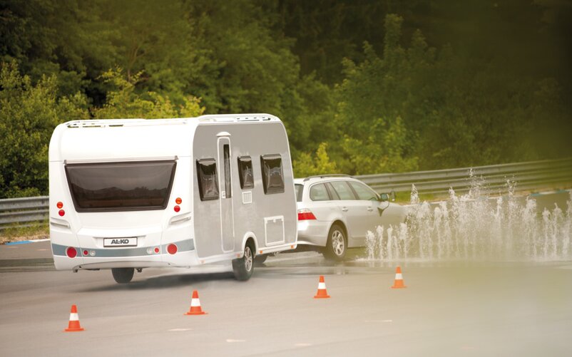 A car with a caravan is taking part in a driver safety training. | © AL-KO