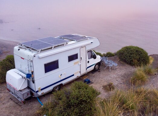 Ein Wohnmobil steht an einer Küste mit Blick aufs Meer.