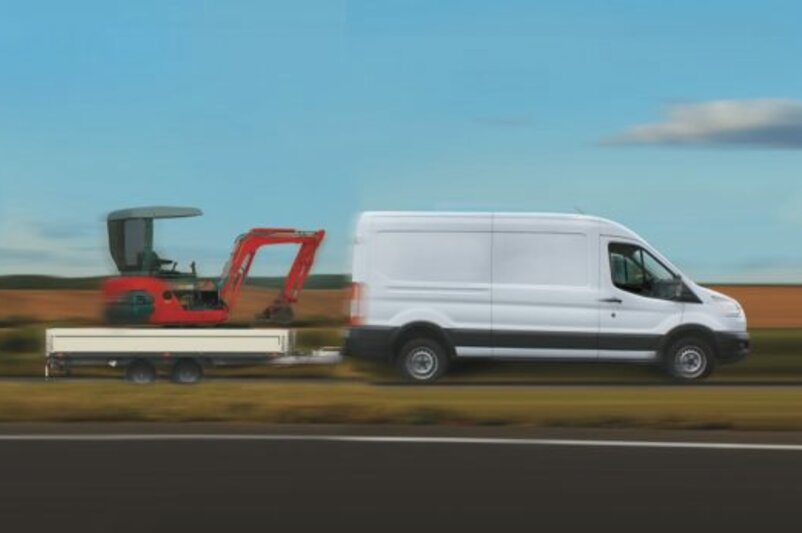 Ein Transporter mit einer hohen Anhängerlast zieht einen Anhänger mit Minibagger.