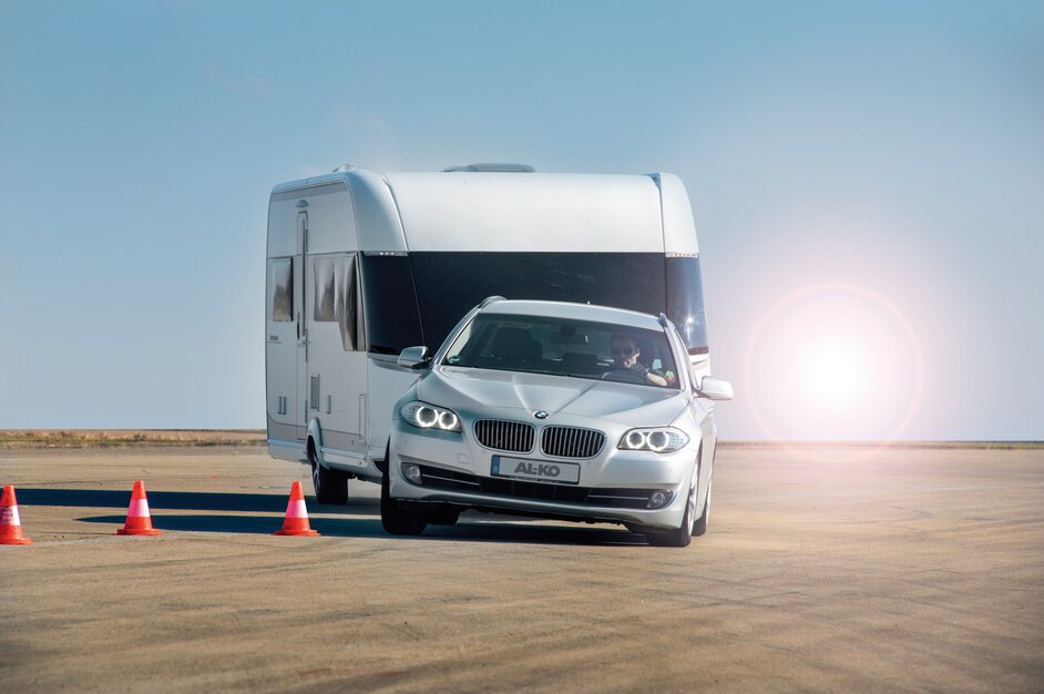 A car towing a camper trailer drives through a safety course. | © AL-KO VT